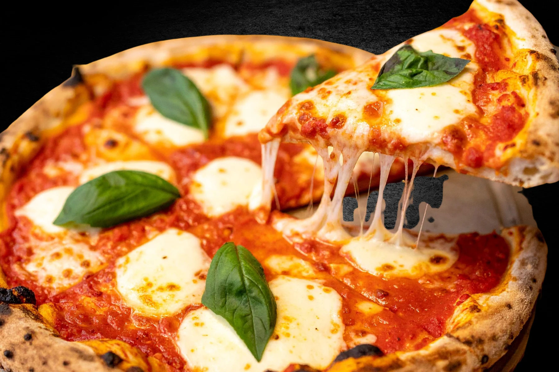 Basil and mozzarella pizza with a slice being lifted